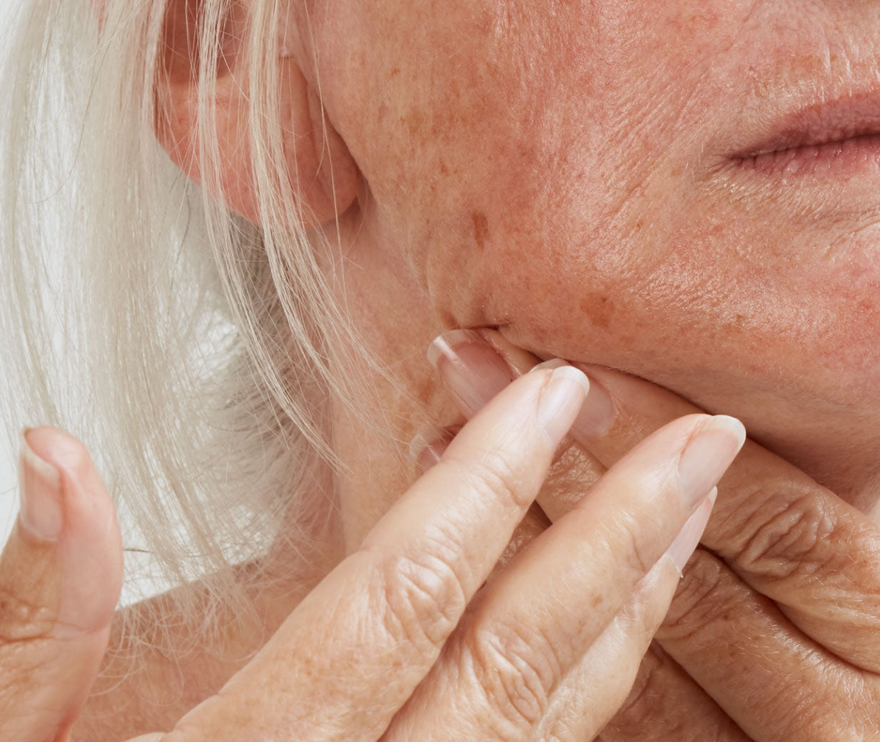 mature woman applying skincare